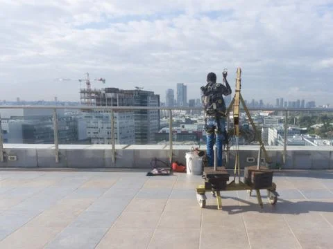 Window cleaning employee with work tools and city background Stock Photos