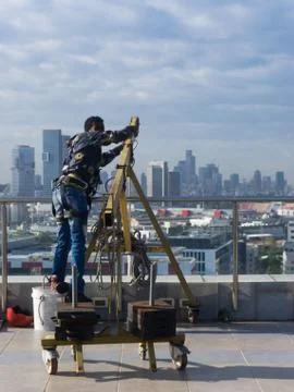 Window cleaning employee with work tools and city background Stock Photos