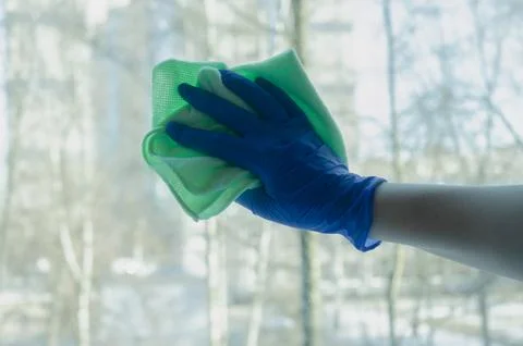 Window cleaning. Gloved hands with cleaning cloth Stock Photos