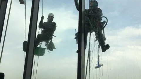 Window cleaning by industrial climbers at height Stock Footage 252948677