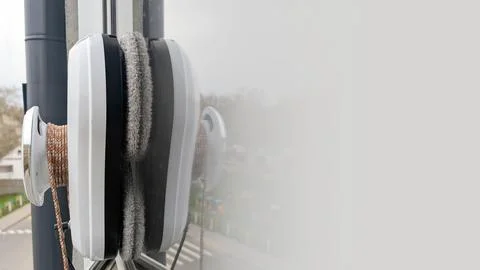 Window cleaning tool with dual suction cups attached to glass surface Stock Photos