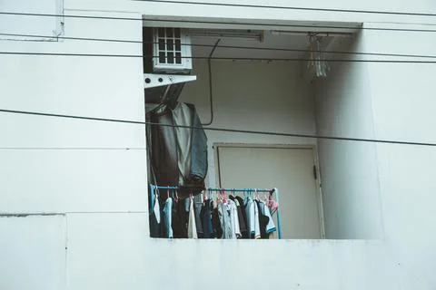 A window with clothes hanging out of it Stock Photos