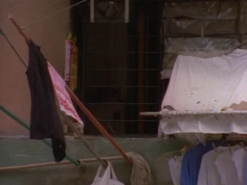 Window with clothes hanging on a stick on a windy day Stock Footage 79878777