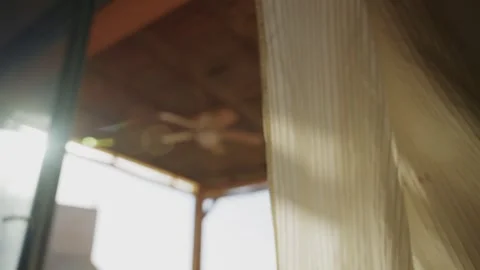 Window curtain blowing in the wind in house as sunlight shines from outside Stock Footage 316073383