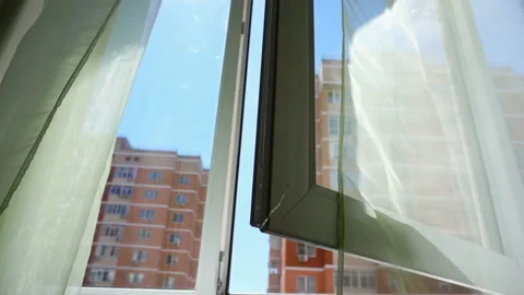 Window with curtains and a view of the sky and city. Conceptual story of the Stock Footage 93650598