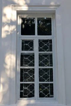 Window with a decorative grill design and sunlight in a residential building Stock Photos