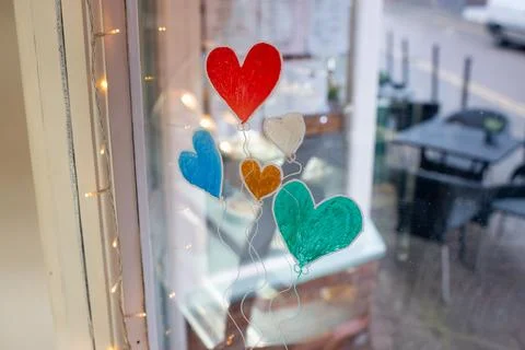A window with a drawing of five hearts and balloons 스톡 사진