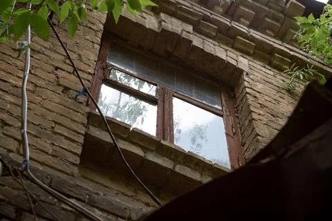 Window on the facade of an old abandoned brick townhouse of the 19th centur.. Stock Photos