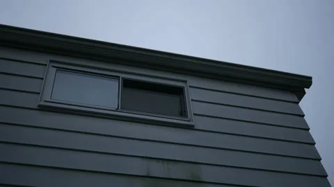 A window facing the rear of a ranch residential home Vídeo Stock 217940857