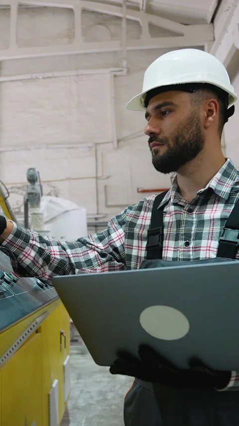 Window factory worker operating machinery with laptop Stock Footage 314584655