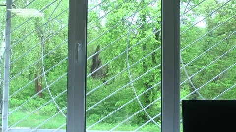 Window with a figured lattice on the wall of an old half-abandoned house. Stock Footage 308825293