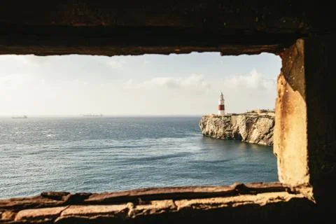 Window in foreground providing view of lighthouse Stock Photos