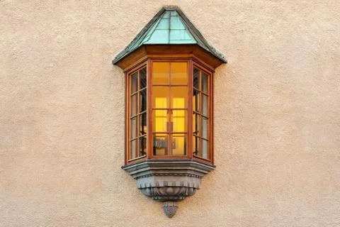 The window in the form of a bay window is located in the middle of the plaste Stock Photos