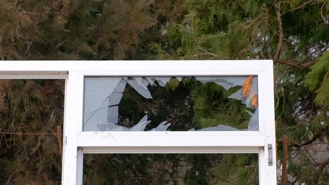 Window frame with broken glass on the background of trees in the city Park. Video stock 117896744