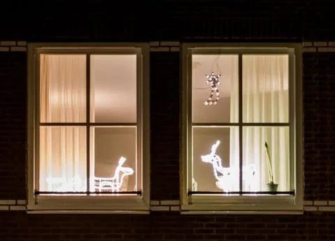 Window frameworks with christmas light decorations behind them Stock Photos