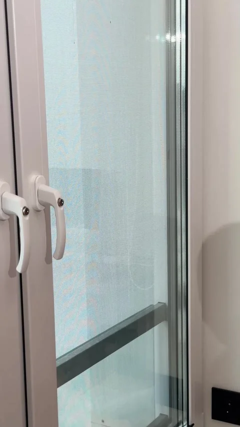 Window glass maintenance featuring an unseen hand sliding a squeegee scrape.. Stock Footage 346153643