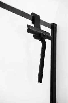 Window glass squeegee. Window cleaning black brush is appendant on shower glass Stock Photos