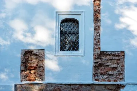 Window with a grille on the wall. Stock Photos