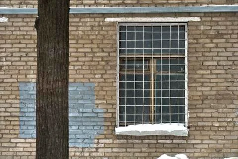 Window grille on a window of old soviet brick house 写真素材