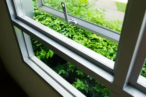 Window at ground floor was opened for good air flow, out side is green garden Stock Photos