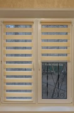 Window half closed with striped blinds day-night Foto stock
