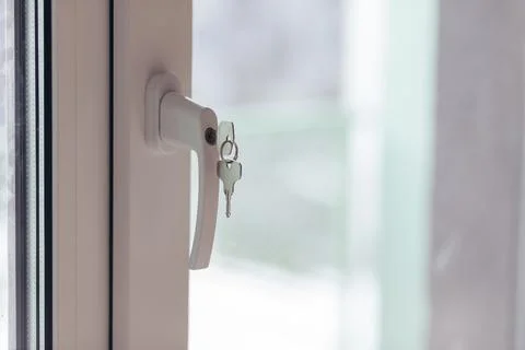 Window Handle With Keys Inserted In Lock. Security And Access Detail In Interior Photos