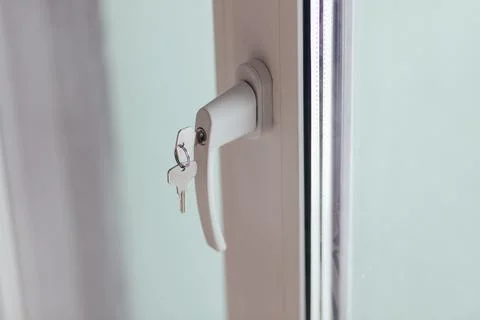 Window Handle With Keys Inserted In Lock. Security And Access Detail In Interior Photos