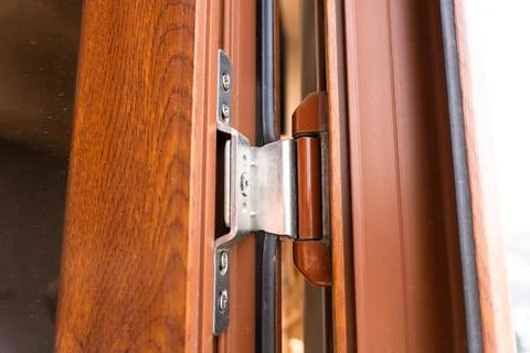 Window hinges, repair of brown plastic windows in an apartment, hinge repair. Foto stock