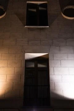 The window is illuminated at night from both sides by spotlights Stock Photos