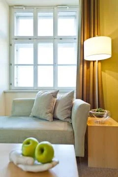 Window illuminates a seating area with fruit in the foreground Stock Photos