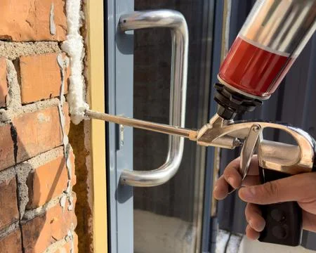 Window installation. The process of insulating windows with construction foam. A Stock Photos