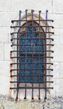 Window with iron grating on stone wall Stock Photos