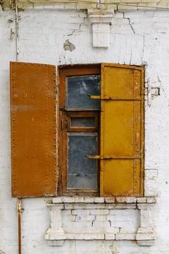 A window with iron shutters on the facade of an old building Stock Photos