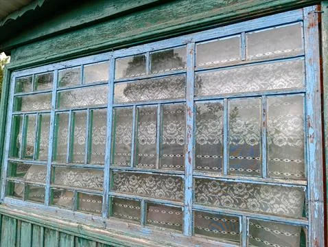A window with lace on the side of a building Stock Photos