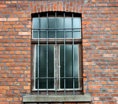 Window with a lattice on the background of an old brick wall. Stock Photos