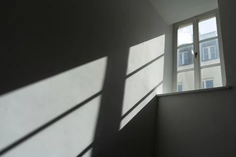 Window light and shadow projection on a white wall in empty room Stock Photos