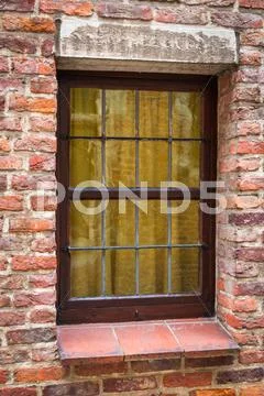 Window of a medieval building with old brick wall Stock Photos