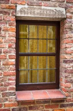 Window of a medieval building with old brick wall Stock Photos