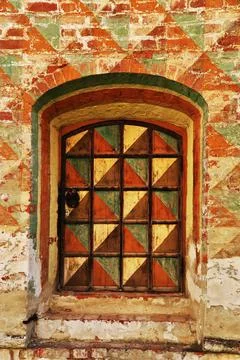 Window with metal bars. Window in an old brick wall of a house. Stock Photos