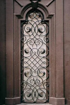 A window with a metal grille with patterns with a lilac sheen. A window wi... Fotos de archivo