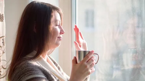 Window observation. Rest in a cozy house. The girl greets a friend. 스톡 동영상 169386493