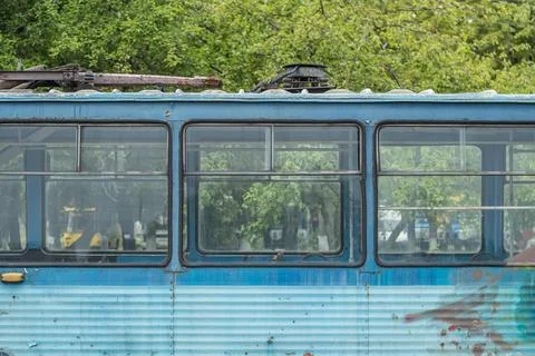 Window of old abandoned empty blue tram. Stock Photos