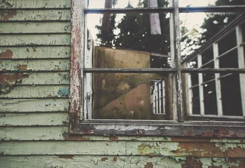 A window of an old aged ruined building with aged paint and wooden wall. Free Stock Photos