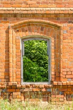Window of the old destroyed building of red brick through which you can see g Foto stock