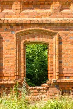 Window of the old destroyed building of red brick through which you can see g Stock Photos