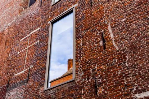 Window on the old red brick building. Old retro house made of the red bricks. Fotos de archivo