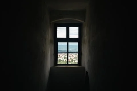 A window in an old tower overlooking the mountains. Stock Photos