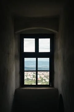 A window in an old tower overlooking the mountains. Stock Photos