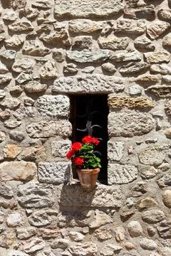 Window in an old wall with flower Window in an old rubble wall with flower... Fotos de archivo