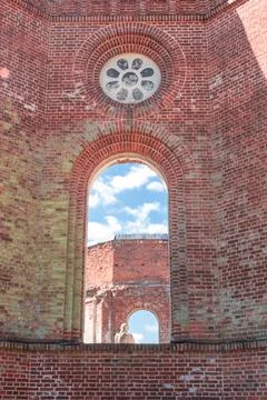The window opening is made of red brick. A hole in the cast. Stock Photos